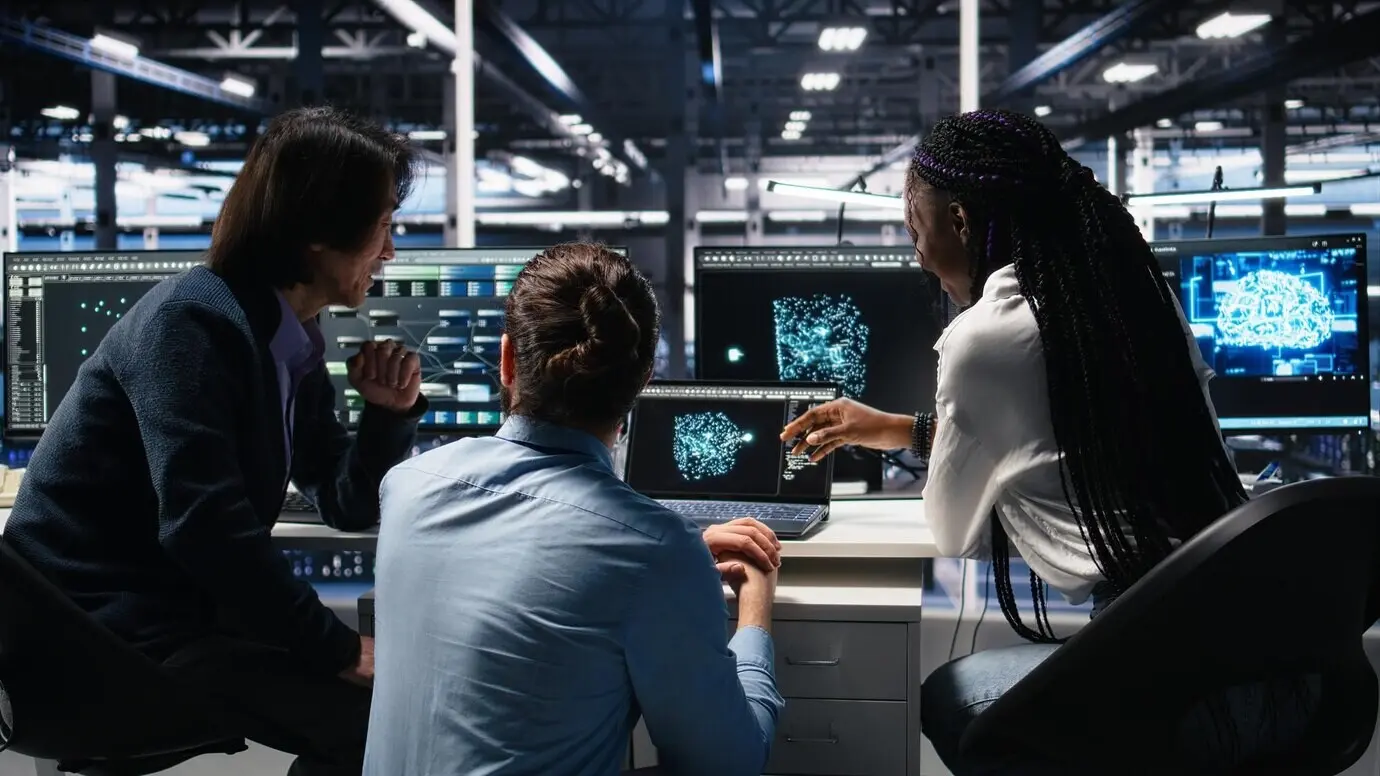Computer scientists in a server room using AI to analyze infrastructure diagnostics.