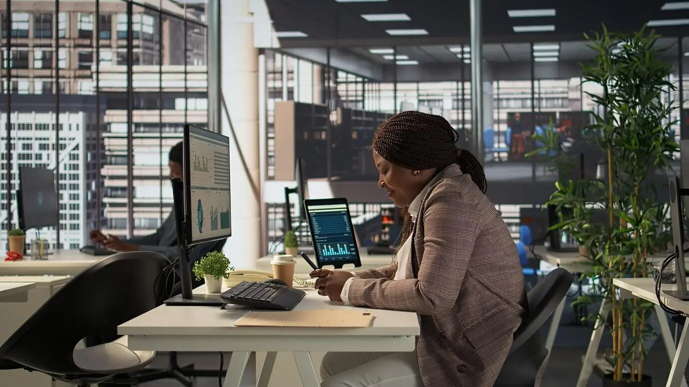 A Black business employee is browsing social media webpages on her phone.