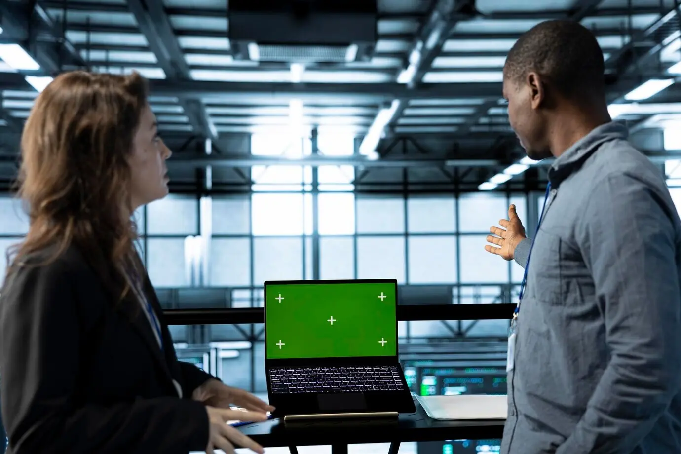 A team of server farm engineers using a laptop with an isolated screen mockup.